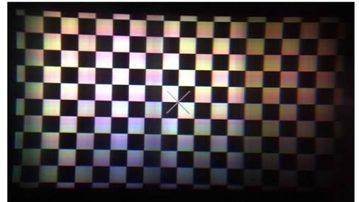 Projection from a diffractive waveguide exhibiting non-uniformity of both brightness and color tones on mid-level gray pixels.