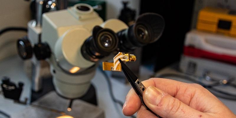 The image shows the quantum cascade laser, on its mounting, being held by a set of tweezers